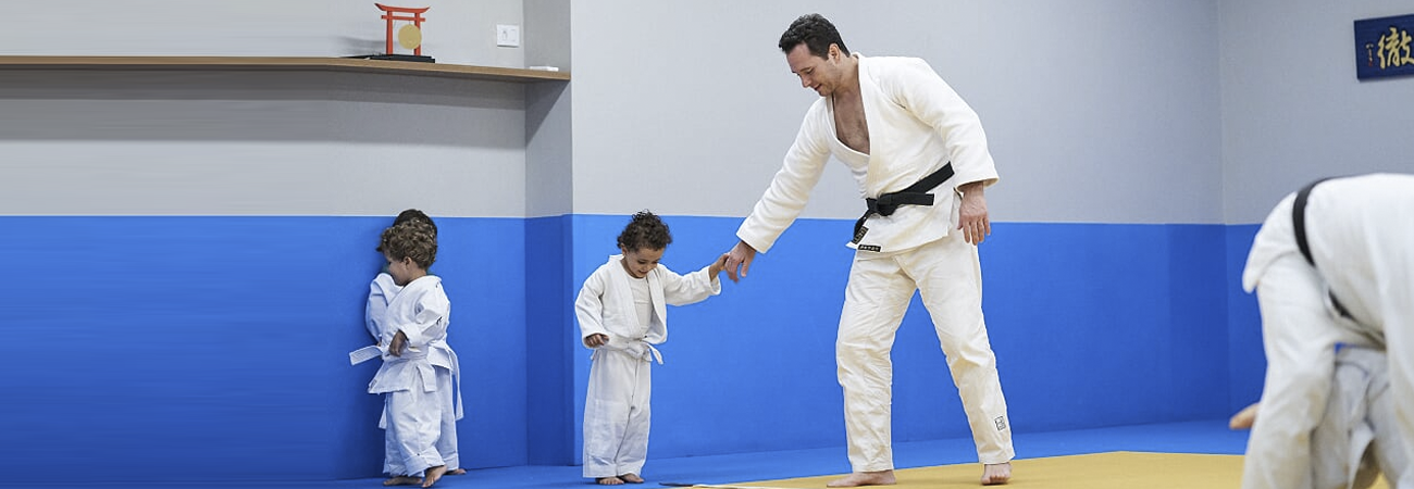 Tiago segurando mão de judoca criança